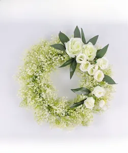Close-up of white artificial rose wreath with baby's breath and green foliage details