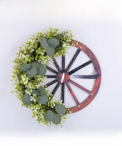 Détail d'une couronne de bienvenue en roue de charrette avec feuilles d'eucalyptus