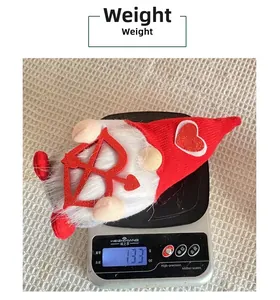Balance de cuisine montrant le poids de 133g d'un gnome de la Saint-Valentin à cœur
