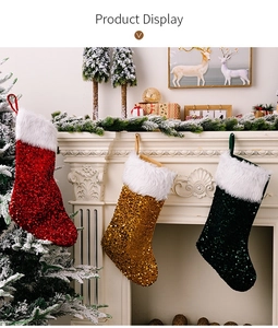 Gros plan de chaussettes de Noël en paillettes rouges dorées et vertes sur une cheminée