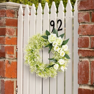 Artificial white rose wreath hanging on white wooden fence for wedding party decoration