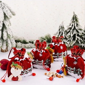 Detail of red burlap Christmas drawstring gift bags with Santa Claus and snowflake motifs