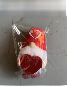 Détail d'un gnome de la Saint-Valentin avec bonnet rouge et cœur brillant sous emballage