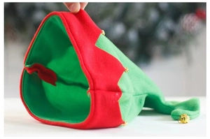Close-up of red and green velvet Christmas elf hat featuring golden bells and sawtooth trim