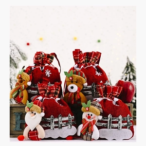 Detail of burlap Christmas gift bags featuring 3D Santa, snowman, elk and bear dolls