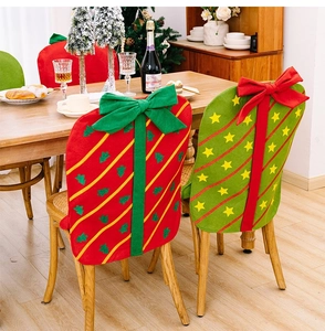 Dettaglio di coprisedie natalizi con grandi fiocchi decorativi in un ambiente festivo