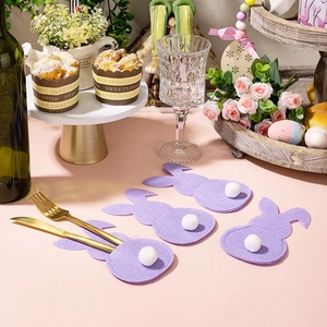 Easter purple felt bunny cutlery holders with white fluffy tails on a festive table