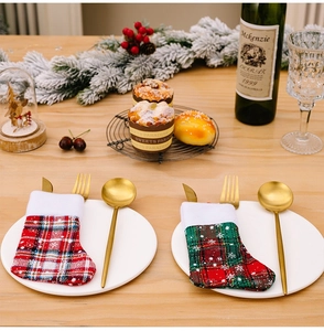 Plaid Christmas stocking cutlery holders on a festive dinner table with gold utensils
