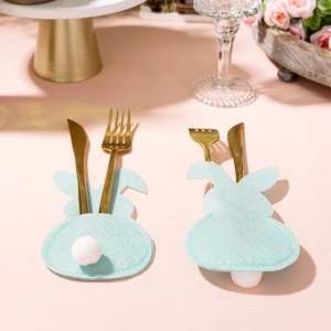 Detail of mint green rabbit cutlery holders with fuzzy tails on pink festive table