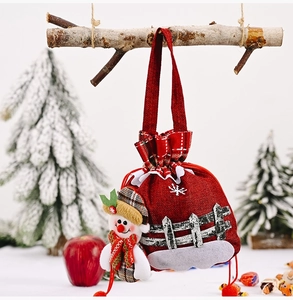 Close-up of burlap Christmas gift bag with 3D snowman, plaid scarf, and red drawstring