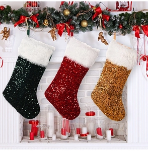 Détail de chaussettes de Noël à paillettes scintillantes avec revers en peluche sur la cheminée