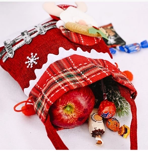 Close-up of a red burlap Christmas gift bag with a plush reindeer and snowflake detail