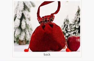 Back view of burlap Christmas gift bag with red pompoms and plaid trim details