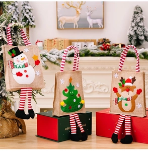 Three burlap Christmas gift bags with striped legs and holiday patterns on gift boxes