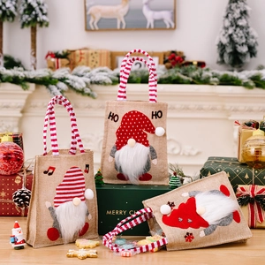 Tres bolsas de regalo de Navidad en arpillera con diseños de gnomos y asas de rayas