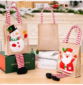 Detail view of burlap Christmas gift bags with 3D cartoon motifs and striped long legs