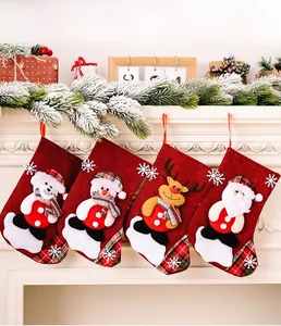 Detailed view of four rustic Christmas stockings hanging on fireplace with embroidery