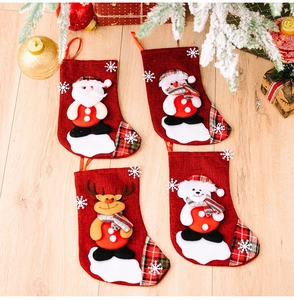 Close-up of four red burlap Christmas stockings with 3D Santa, Snowman and Reindeer applique