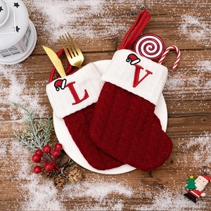Red and white knitted Christmas stockings with embroidered letters for holiday decor