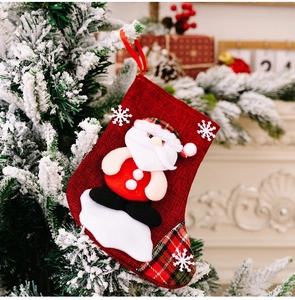 Close-up of small red burlap Christmas stocking with 3D Santa Claus and snowflake detail