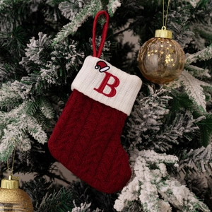 Detailed macro of red knitted Christmas stocking with white cuff and embroidered letter B