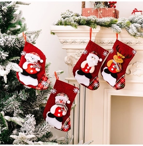 Detailed view of four small red burlap Christmas stockings with 3D holiday characters