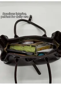 Top view of spacious brown tote bag interior filled with daily essentials and cosmetics