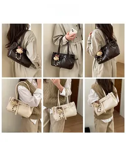 Detail showing vintage leather underarm bags in brown and beige with bear charm