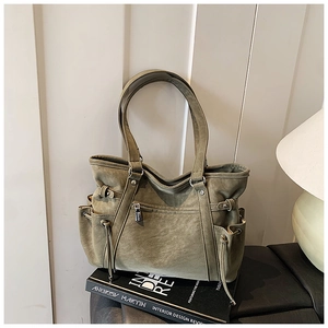 Detalle del bolso tote verde oliva vintage con bolsillos con cordón y cuero PU mate