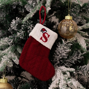 Detailed macro shot of red knitted Christmas stocking ornament with embroidered letter S