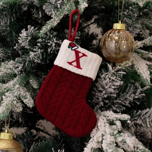 Red knit Christmas stocking with white cuff and embroidered letter X on tree