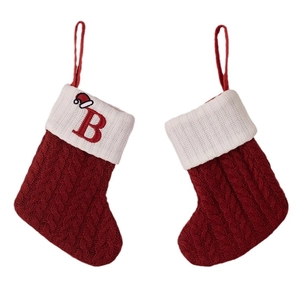 Red knit Christmas stockings with cable patterns and letter B embroidery on white rim