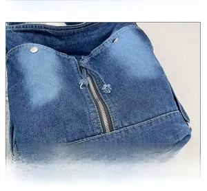 Detailansicht der gewaschenen Jeans-Tasche mit Metallnieten und mittlerem Reißverschluss
