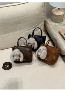 Détail de sacs fourre-tout vintage avec pendentifs lapin et bandoulières amovibles