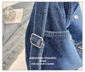 Detailansicht der Denim-Tragetasche mit Metallschnalle und Kontrastnähten für Damen