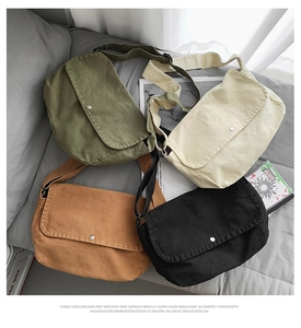 Detalle de bolsos bandolera grandes de lona en verde, beige, marrón y negro con cierres metálicos