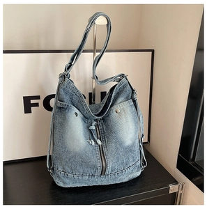 Detail der blauen Vintage-Jeans-Tasche mit verwaschenem Look und vertikalen Reißverschlüssen