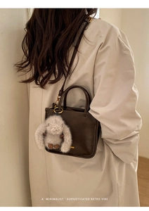 Détail du sac seau rétro marron foncé avec bandoulière et breloque lapin en peluche