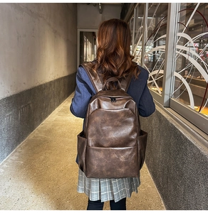 Brown PU leather backpack detail showing large capacity and textured synthetic leather
