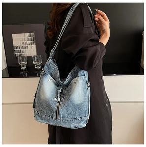 Detail der blauen Vintage-Jeans-Tasche mit Metallreißverschlüssen und Nieten an der Schulter