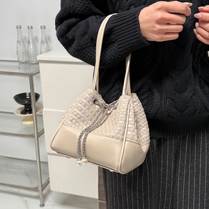 Détail du sac seau tissé beige avec cordon de serrage en perles et finition cuir lisse