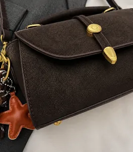 Detailansicht der braunen Retrotasche mit weicher Mattoptik und goldenem Sternanhänger