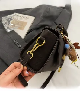 Detail der dunkelbraunen matten Ledertasche mit glänzenden goldfarbenen Metallbeschlägen