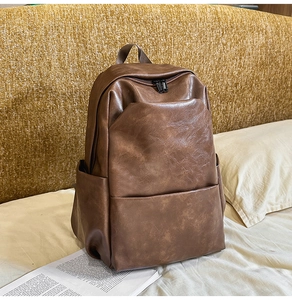 Close-up of dark brown PU leather backpack with vintage texture and double zipper detail
