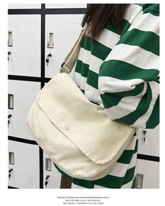 Detalle del bolso bandolera de lona con hebilla metálica y correa ajustable al hombro