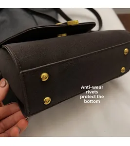 Detailansicht der dunkelbraunen Tasche mit vier goldenen Schutznuten aus Metall am Boden