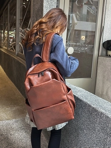 Minimalist large capacity dark brown PU leather backpack for men and women on outdoor street