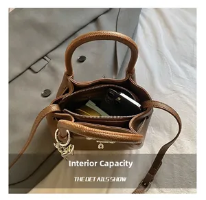 Vue de dessus du sac seau marron en cuir grainé montrant l'espace intérieur de rangement