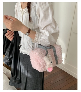 Close-up of pink plush shoulder bag with grey strap and a cute white bunny charm