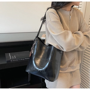 Detail der schwarzen Beuteltasche mit MIXXO COEOP-Prägung und glatter PU-Ledertextur